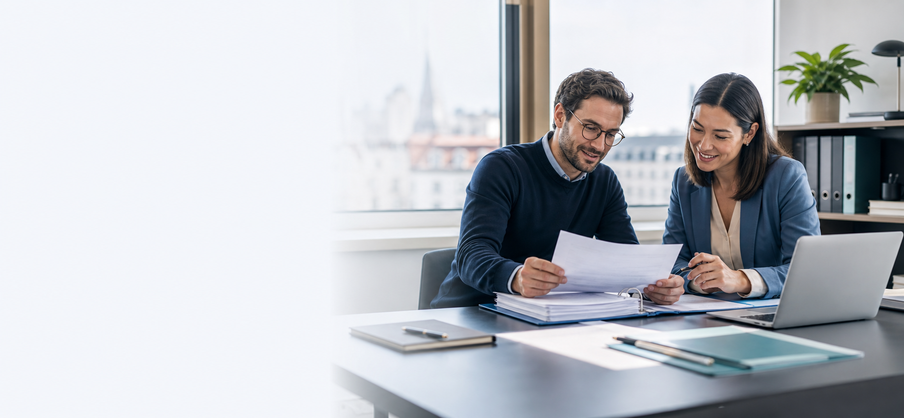 Une entrepreneuse et son assistant administratif examinent des documents ensemble.